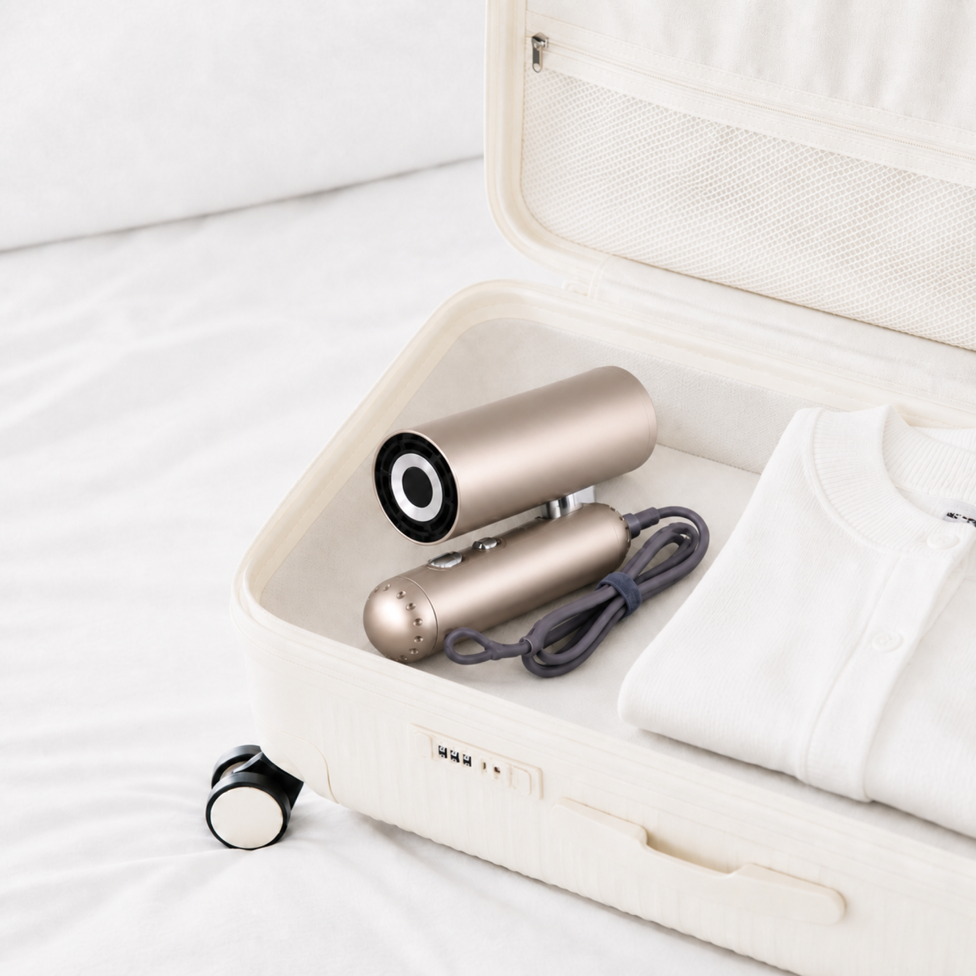 Champagne-gold foldable high-speed hair dryer packed inside a travel suitcase